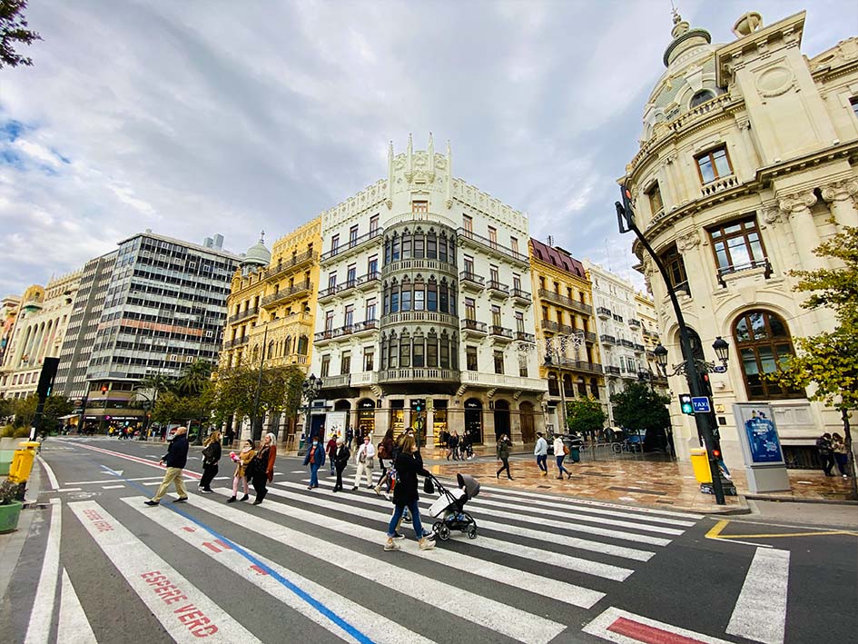 expat impact on real estate prices in Valencia Spain. Bildings with people in crosswalks