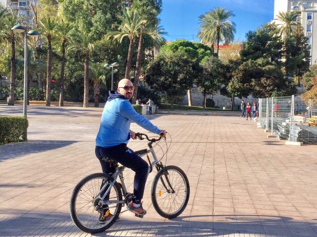 man bike riding in blue hoodie and black pants in  getting around in valencia